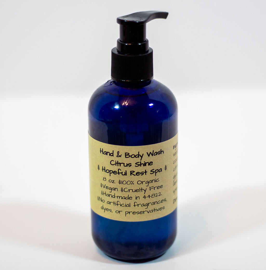 A cobalt blue pump bottle of hand and body wash with a beige label reading 'Citrus Shine & Hopeful Rest Spa'.