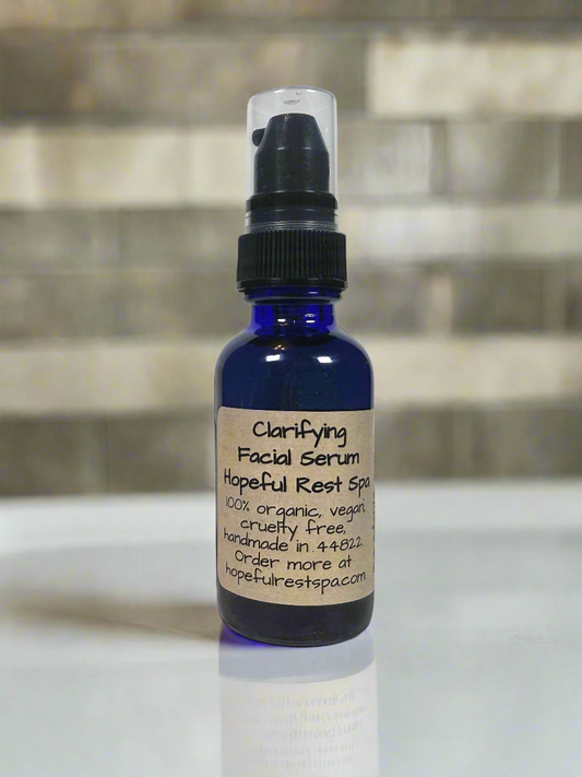 Facial serum in a blue glass bottle with a label on a reflective surface with a blurred background