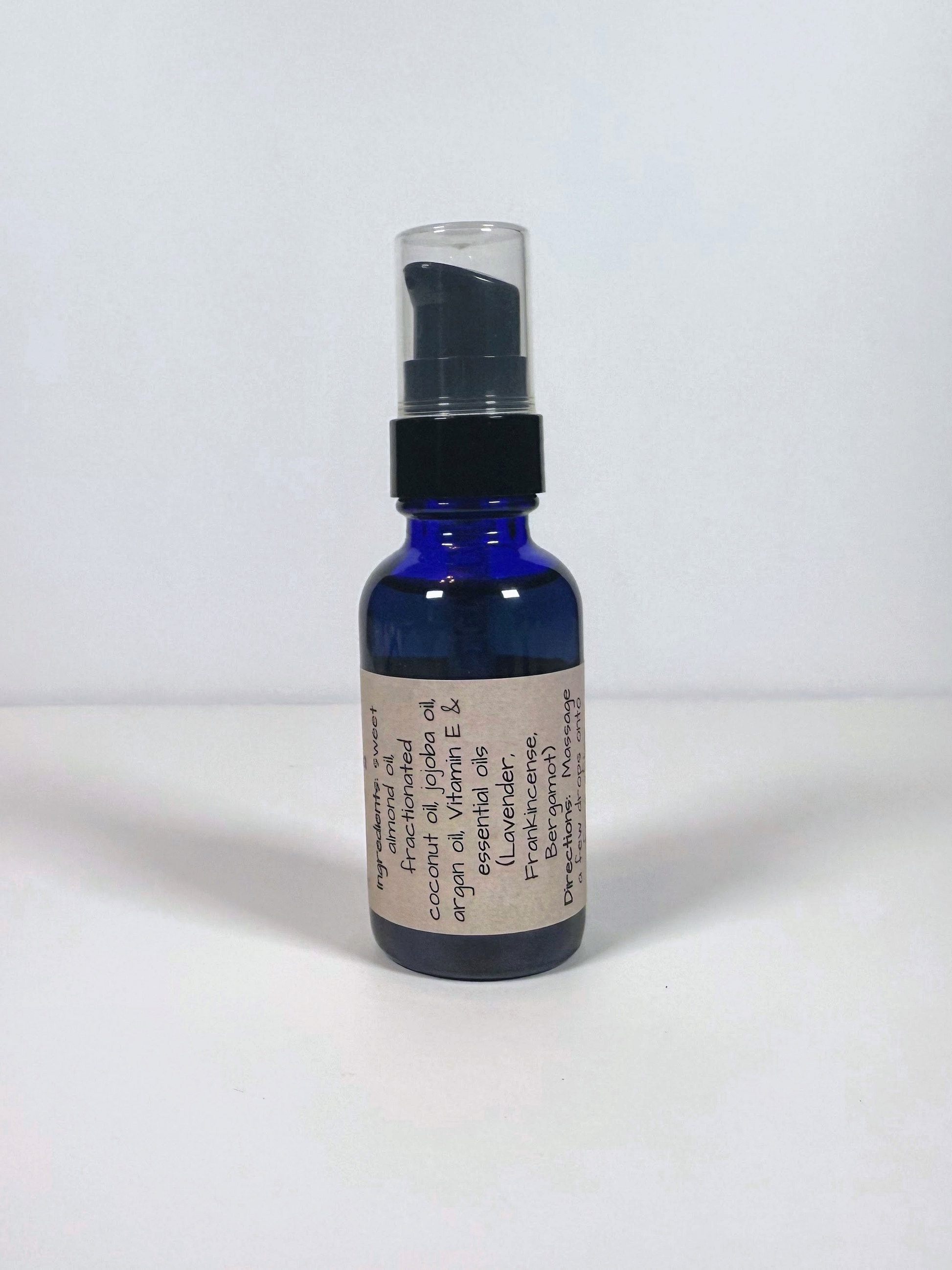 Blue glass bottle with a black spray cap on a white background