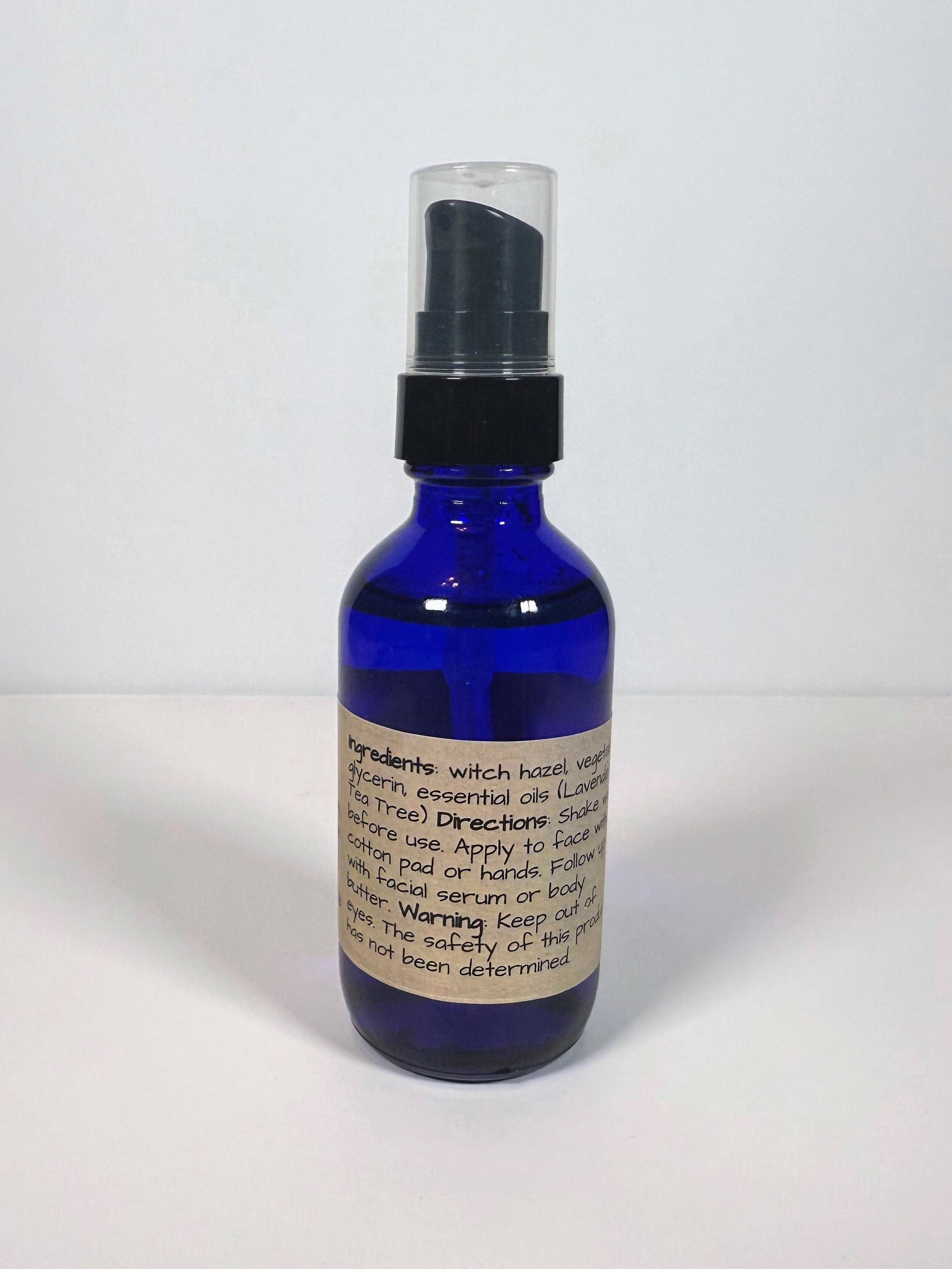 Blue glass bottle with a black cap on a white background